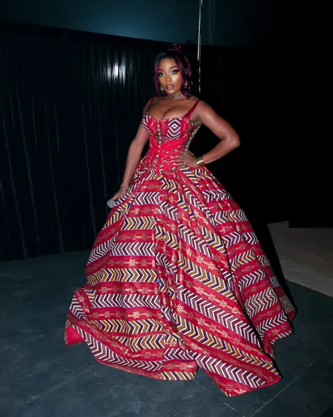 Efya in a full red and white patterned gown